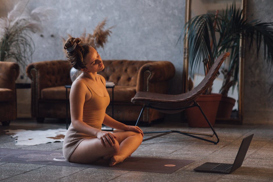 Person gently stretching their back while sitting on a yoga mat.